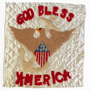 A square quilted patch featuring a punch needle embroidery brown eagle holding a beige anchor, with a red, white, and blue American flag motif on the chest. The patch has red embroidered text reading 'GOD BLESS' at the top and 'AMERICA' at the bottom, set against a creamy off white background.